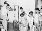 相片：60年代公屋居民在食水管制下排隊取水。