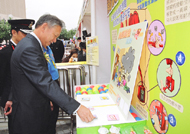 Photo: Secretary for Security, Mr Ambrose Lee, shows interest in the Housing Authority's booth game.