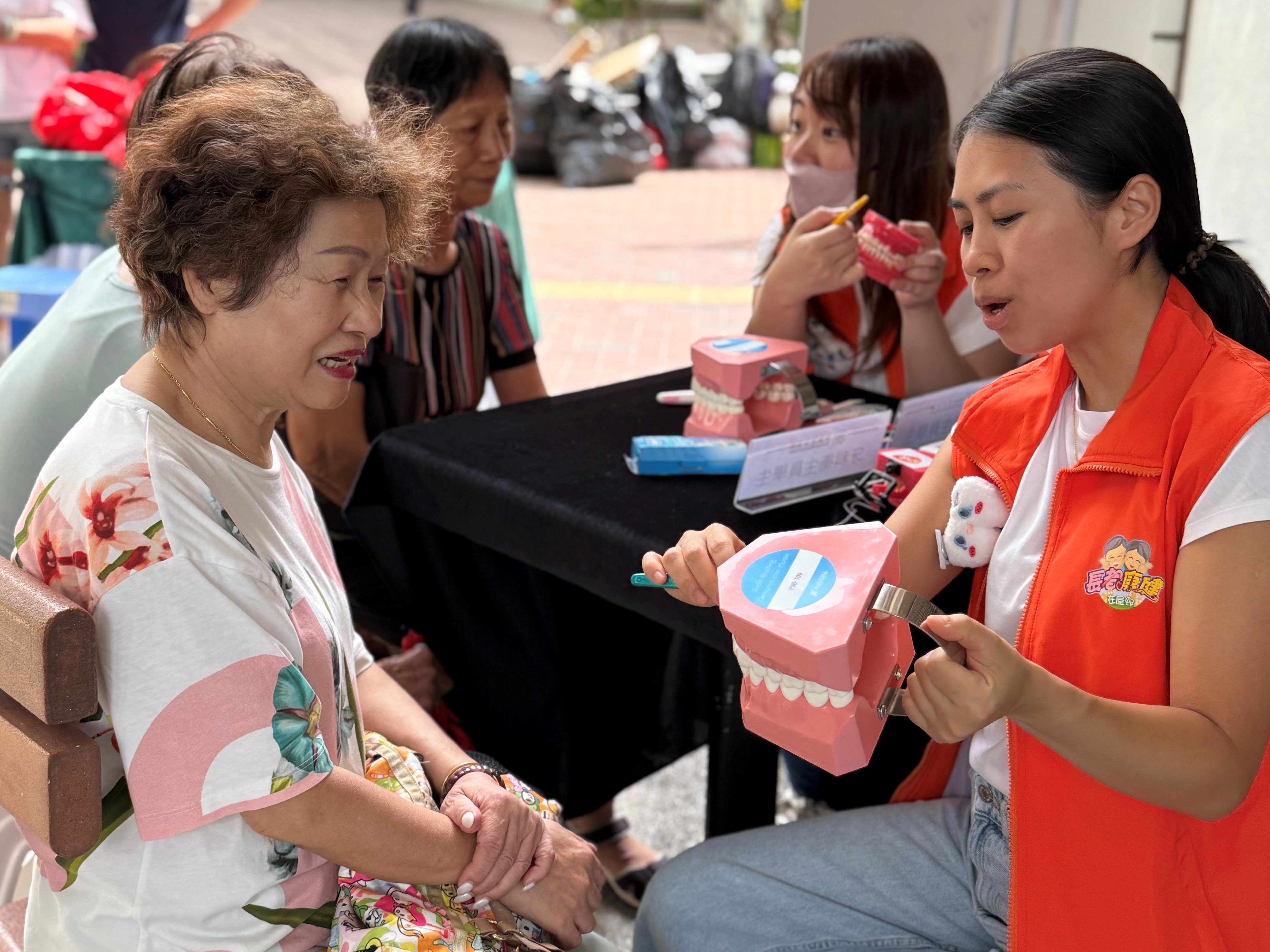 相片：菲腊牙科医院牙科卫生员学生为长者讲解常见口腔疾病及护理知识。