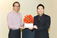 相片：晉升為總技術主任(建築工程)的鍾志健(左)，獲副署長(屋邨管理)李國榮頒授升職賀函。
