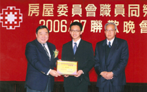 相片：我的兒子(中)在2006年中學會考考獲優異成績，由前房屋署署長陳鎮源(左)頒發獎學金，右為我本人。