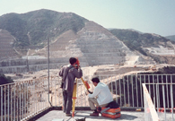 相片： 1989年測量人員在耀東邨地盤平整工程中(左)以及在防空洞內作測量 (右)。