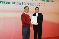 相片：總屋宇事務助理麥偉明(左)接受公務員事務局局長鄧國威頒發獎狀。
