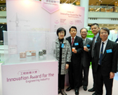 相片：副署長(發展及建築)馮宜萱(左一)聯同工程團隊攝於頒獎典禮上。旁為獲獎的建造創新技術展品。