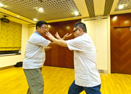 相片：(左至右)學員譚健明(左)示範如何使用八卦掌，擊退來襲的敵人。