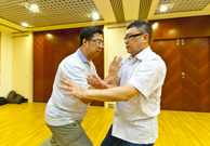 相片：(左至右)學員譚健明(左)示範如何使用八卦掌，擊退來襲的敵人。