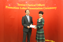 相片：公務員事務局一般職系處長陳炳輝(左)祝賀獲晉升為高級文書主任的文連英。