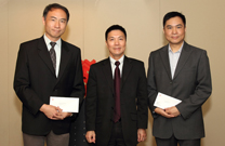 相片：副署長(屋邨管理)李國榮祝賀晉升為高級屋宇保養測量師的楊國寶(左)及錢漢輝(右)。