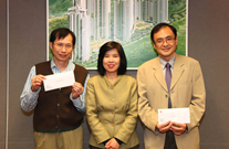 相片：晉升為首席測量主任(工料)的高志強(左)和吳煜(右)獲助理署長(工務)(二)嚴小玲頒授升職賀函。