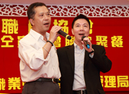 相片：副署長(屋邨管理)李國榮(右)與房屋署工程職員協會主席何倍昇合唱助慶。