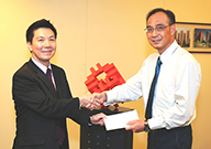 相片：副署長(屋邨管理)李國榮(左)頒授升職賀函予獲擢升為總技術主任(土木工程)的何裕文。