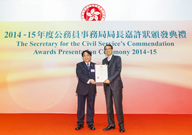 相片：高級產業測量師文家禮(左)接受公務員事務局局長鄧國威頒發獎狀。