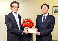 相片：運輸及房屋局常任秘書長(房屋)應耀康(左)頒授賀函予獲擢升為總建築師的許炳照。