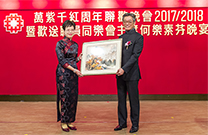 相片：同樂會會長應耀康（右）代表同樂會，送贈由書畫小組繪畫的國畫予主席何樂素芬。
