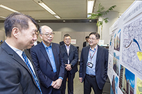 相片：運輸及房屋局局長陳帆（左二）走訪策略處轄下的重建分組，助理署長（房屋資助）許炳照（左一）簡介公共屋邨的重建工作。