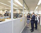 相片：運輸及房屋局局長陳帆（中）走訪機構事務處轄下的資訊科技分處，總監（資訊科技）胡靜怡（左）介紹資訊科技系統的運作。右為運輸及房屋局副局長蘇偉文。