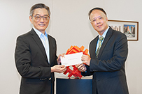 相片：運輸及房屋局常任秘書長（房屋）應耀康（左）頒授升職賀函予獲擢升為總建築師的何國成。