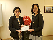 相片：副署長（屋邨管理）黃麗冰（左）頒授升職賀函予獲擢升為高級產業測量師的馮怡。