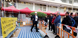相片：屋邨管理處法定規格小組實地講解和示範維修工人在高空工作時使用吊船的安全措施。