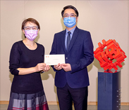 相片：運輸及房屋局常任秘書長（房屋）王天予（左）頒授升職賀函予獲擢升為總屋宇保養測量師的嚴家豪。
