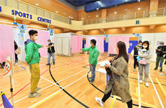 Photo: HD staff (in green jackets) provide administrative support at the community vaccination centre set up at Yau Oi Sports Centre.