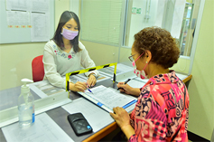 Photo: A staff at Kai Yip Estate Office assists an elderly resident to make online booking for vaccination.