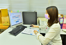 Photo: A staff at Kai Yip Estate Office assists an elderly resident to make online booking for vaccination.