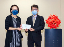 相片：運輸及房屋局常任秘書長（房屋）王天予（左）頒授升職賀函予獲擢升為房屋署助理署長的梁德仁。