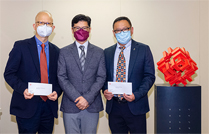 相片：副署长（屋邨管理）杨耀辉（中）颁授升职贺函予获擢升为总技术主任（土木工程）（工务）的钟少明（左）和曾志强。