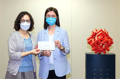 相片：房屋局常任秘書長王天予（左）頒授升職賀函予獲擢升為總房屋事務經理的麥少玲。