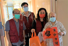 相片︰義工向長者拜早年，祝願身壯力健。