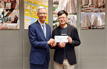 相片：助理署長（工務）林清華（左）頒授升職賀函予獲擢升為首席測量主任（工料）的郭偉業。