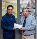 相片：助理署長（發展及採購）梁洪偉（左）頒授升職賀函予獲擢升為首席技術主任（土力工程）的趙芝龍。