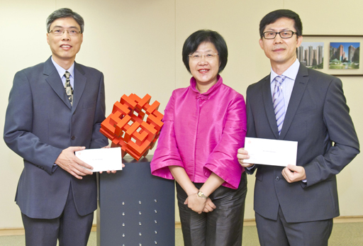 相片：晉升為高級結構工程師的徐偉明(左)和陳應光(右)，獲副署長(發展及建築)馮宜萱頒授升職賀函。