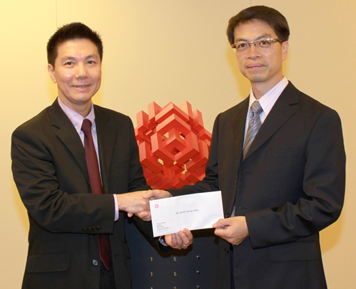 相片：晉升為總技術主任(屋宇裝備)的江鏡清(右)獲副署長(屋邨管理)李國榮頒授升職賀函。