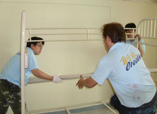 Photo: Staff work together to assemble a bunk bed in a vacant flat.