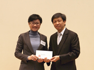 相片：陸玉珊(左)獲公務員事務局一般職系處長陳念德頒授升職賀函。