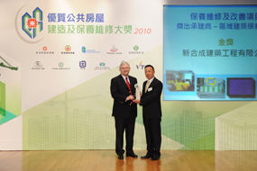 相片：「保養維修及改善項目 - 區域建築保養工程」傑出承建商(金獎)得主與運輸及房屋局常任秘書長(房屋)栢志高(左)合照。