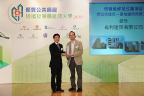 相片:「保養維修及改善項目 - 傑出承建商(區域建築保養工程)」銀獎得主與房屋署副署長(屋邨管理)李國榮(左)合照。