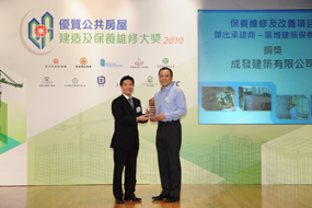 相片:「保養維修及改善項目 - 傑出承建商(區域建築保養工程)」銅獎得主與李國榮(左)合照。