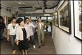 相片：攝影師謝至德(左三)向嘉賓介紹其攝於蘇屋邨的作品。