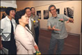相片：攝影師黃勤帶(右一)向嘉賓介紹其攝於石硤尾邨的作品。