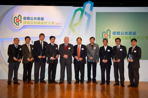 相片：運輸及房屋局常任秘書長(房屋)栢志高太平紳士(左五)致送紀念品予合辦機構(香港建造商會、香港機電工程商聯會、香港建造業分包商聯會、香港建造業總工會、港九電器工程電業器材職工會、勞工處、職業安全健康局、建造業議會及職業訓練局)的代表。