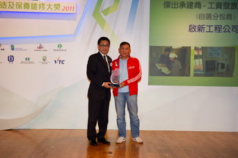 相片：「新工程項目 - 傑出承建商(工資發放監察系統 - 自選分包商)」得主與香港建造業分包商聯會會長伍新華(左)合照。