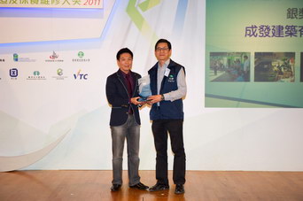 相片：「保養維修及改善項目 - 傑出承建商(區域建築保養工程)」銀奬得主與房屋署副署長(屋邨管理)李國榮太平紳士(左)合照。