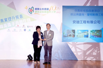 相片：「保养维修及改善项目 - 杰出承建商(屋邨粉饰工程)」得主与房屋署助理署长(屋邨管理)(二)陈少德先生(右)合照。