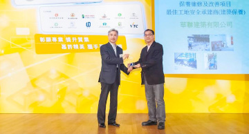 照片：「保养维修及改善项目 － 最佳工地安全承建商」得主与劳工处总职业安全主任胡伟雄(左)合照。