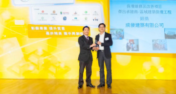 照片：「保养维修及改善项目 － 杰出承建商(区域建筑保养工程 － 银奖)」得主与房屋署副署长(屋邨管理)李国荣(左)合照。