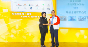 照片：「新工程项目 － 杰出承建商(建筑 － 银奖)」得主与房屋署副署长(发展及建筑)冯宜萱(左)合照。